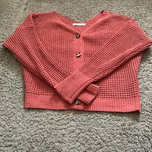 I am selling a red/pink ish button up cardigan.